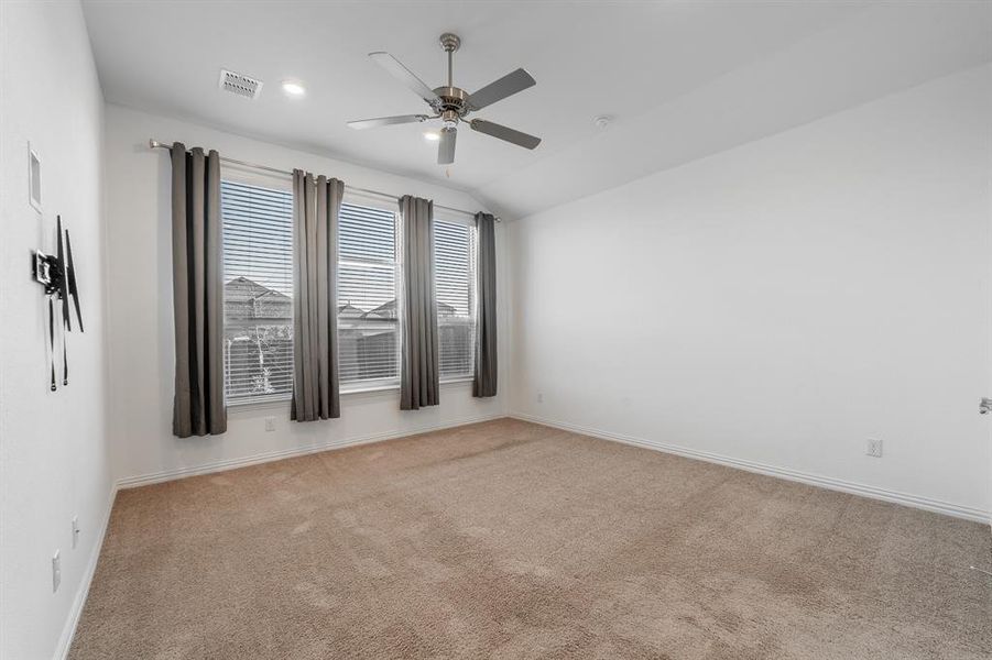 Unfurnished room featuring ceiling fan, lofted ceiling, and light colored carpet