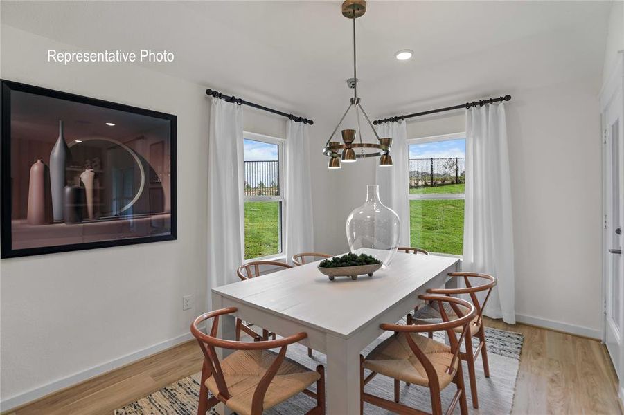 Dining space featuring an inviting chandelier and light wood-type flooring