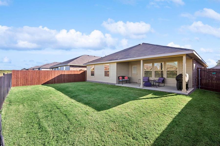 Back of house featuring a lawn and a patio area