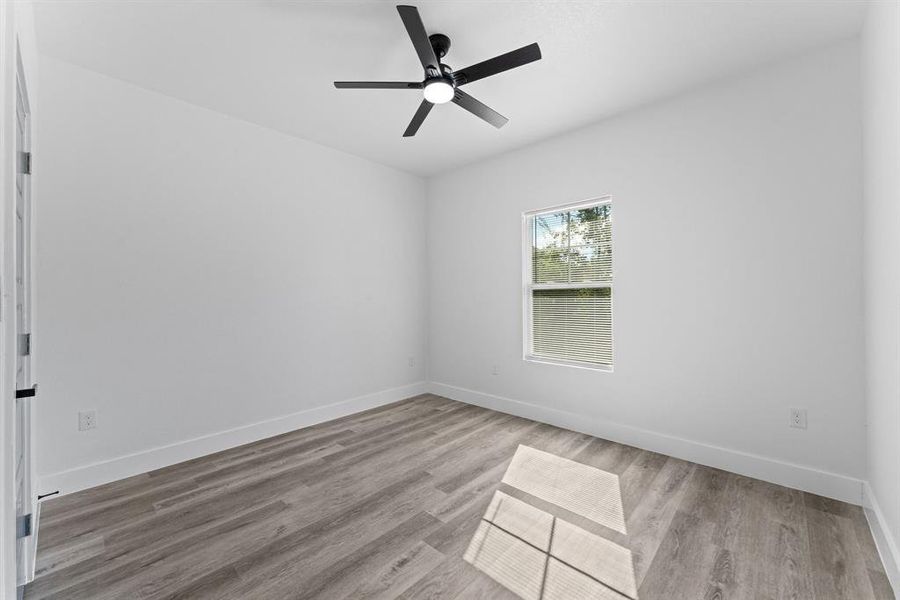 Unfurnished room featuring ceiling fan and light wood-type flooring