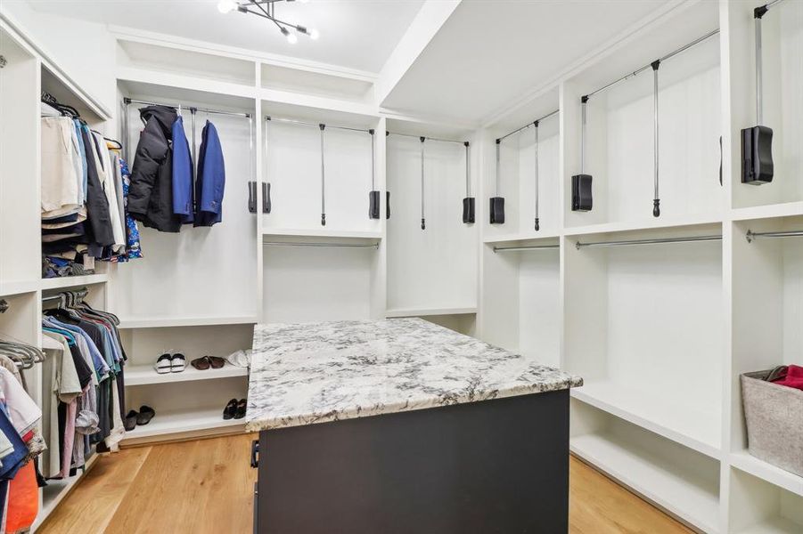 This closet design will impress anyone - It has a useful island/drawer chest combo and plenty of storage!