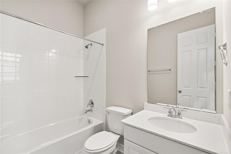 The secondary bath features tile flooring, white cabinetry and light countertops and a shower/tub combo.