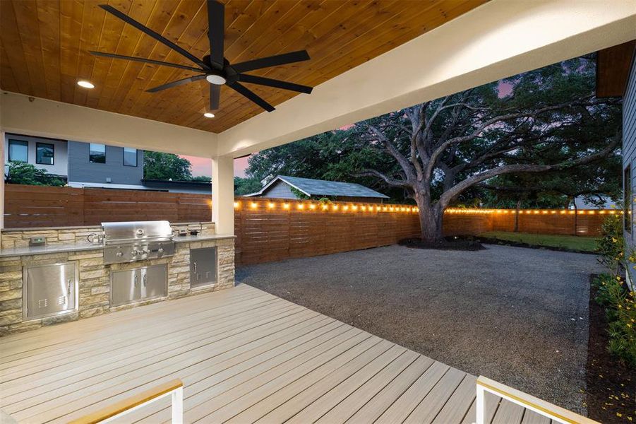 Outside, the backyard is a paradise unto itself—a sprawling oasis complete with a large covered back deck, built-in outdoor kitchen, xeriscaped patio area, and a majestic oak tree providing shade and serenity