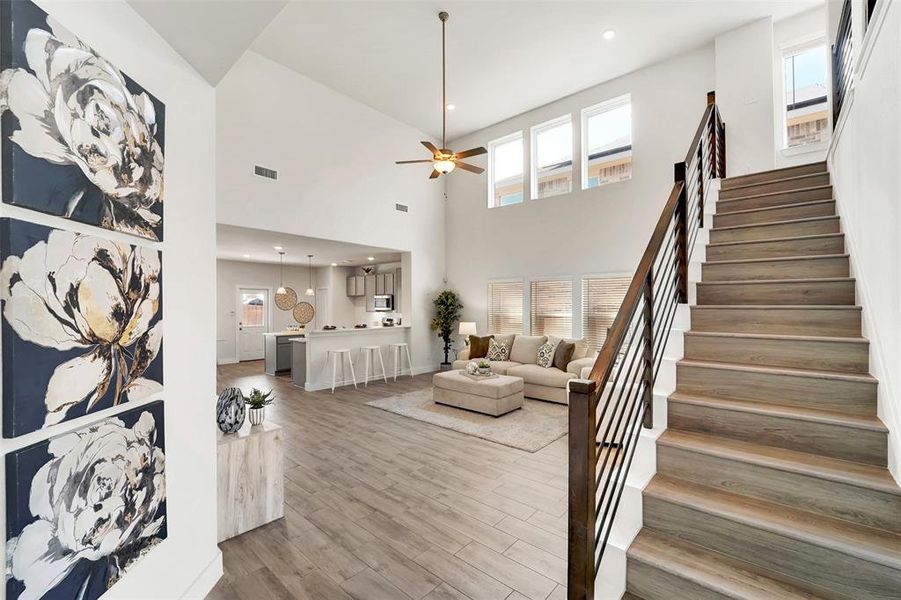 Living room featuring a towering ceiling, hardwood / wood-style floors, and a wealth of natural light