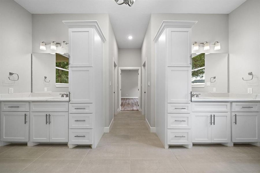 Dual vanity areas with custom cabinets, Moen fixtures and custom cut mirrors. Additional electric plugs in both tall cabinets.