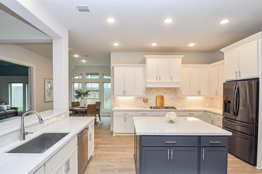 Modern kitchen surrounded by lots of natural light from the large windows throughout the home.