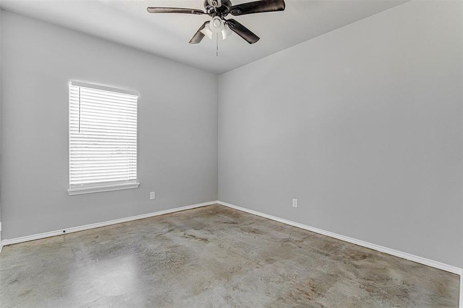 Spare room featuring concrete floors and ceiling fan