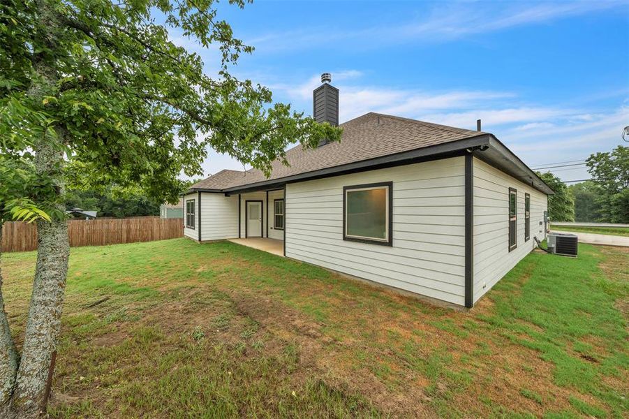 Back of house featuring a yard and cooling unit