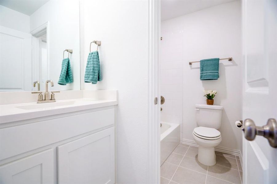 Full bathroom with vanity, shower / tub combination, toilet, and tile patterned floors