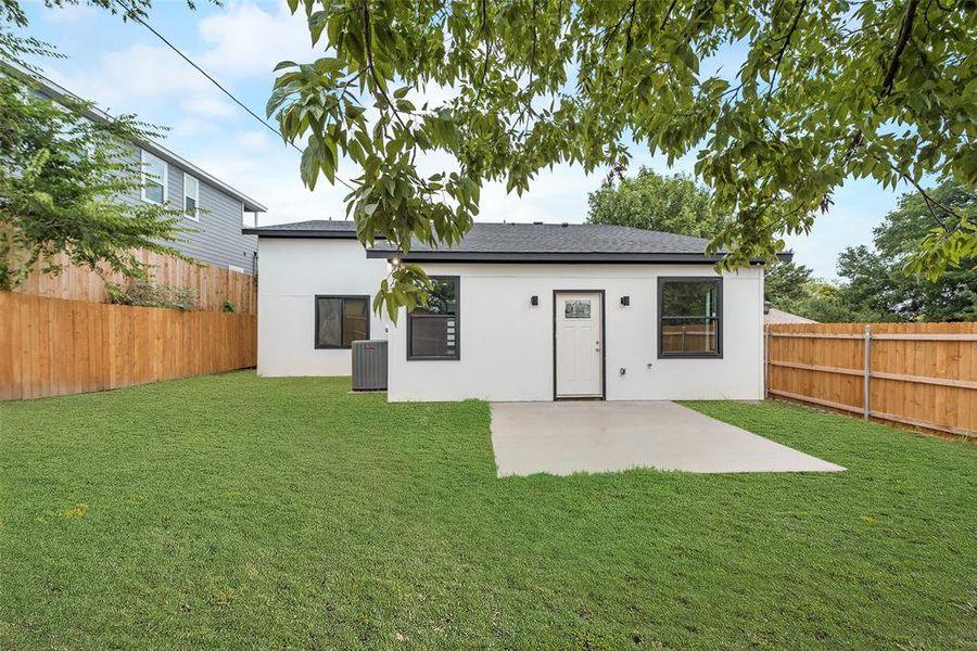 Rear view of property with central AC unit, a lawn, and a patio