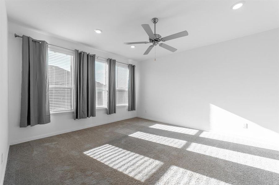 Carpeted empty room featuring ceiling fan