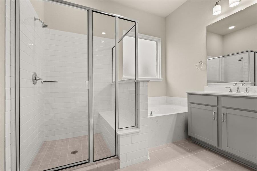 This additional view of your primary bathroom features tile flooring, fresh paint, walk-in shower, a separate garden tub, and a large walk-in closet.