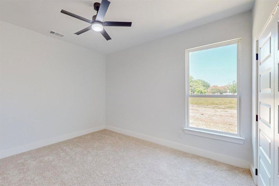 Carpeted empty room with ceiling fan