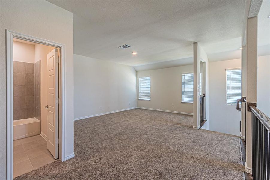 Spare room featuring light carpet and a textured ceiling