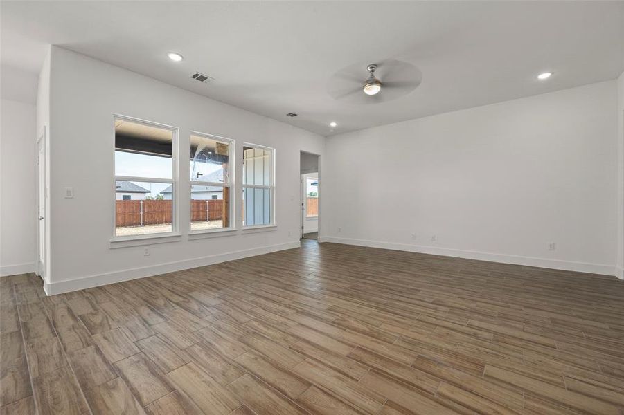Unfurnished living room with ceiling fan and hardwood / wood-style flooring