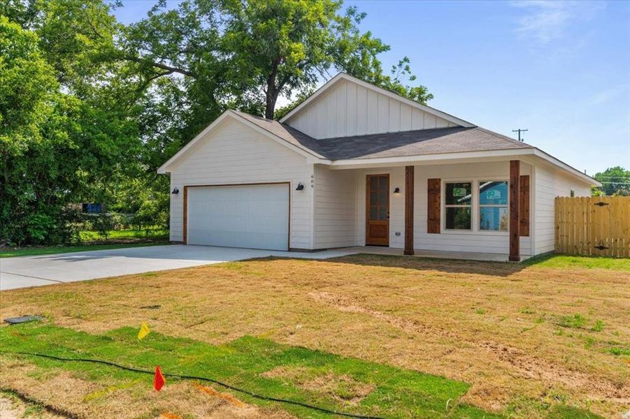 View of front of property with a garage and a front lawn