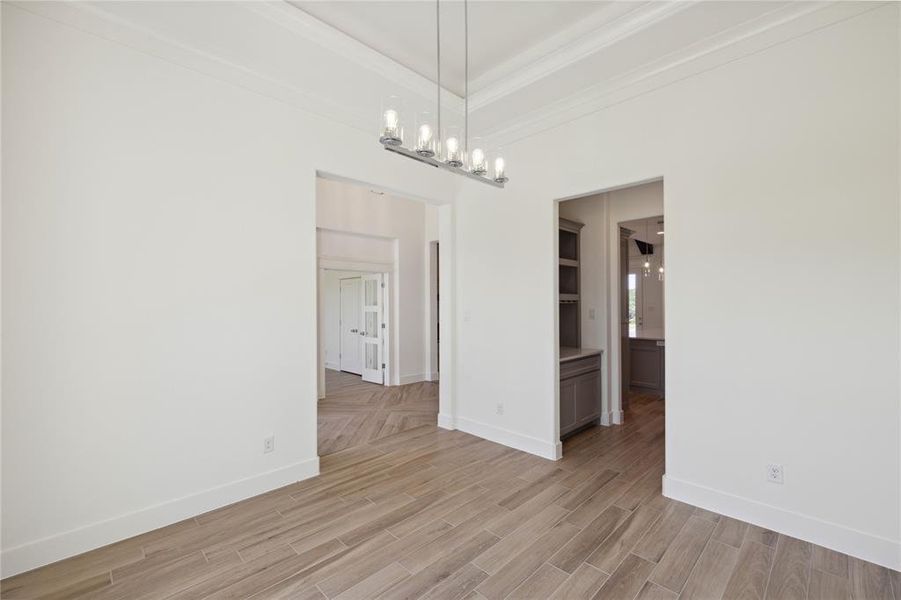 Unfurnished dining area featuring crown molding and light hardwood / wood-style flooring