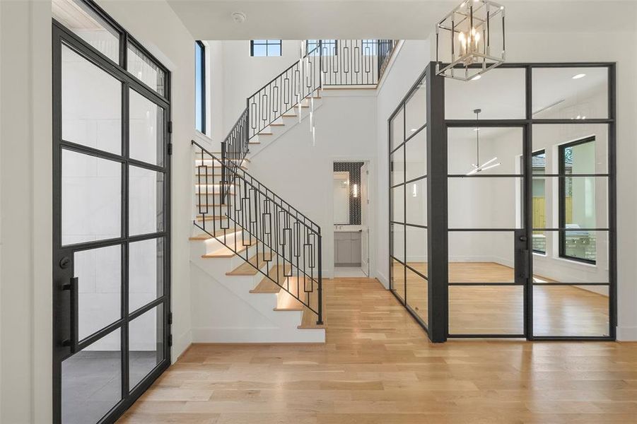 The custom corner wall of windows at the study is a focal point and allows light to flow seamlessly from the two story entry into the study and from the courtyard and lanai into the entry.