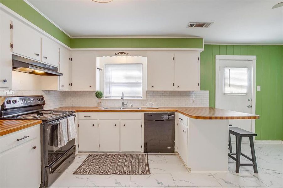 Kitchen featuring white cabinets, black appliances, and sink