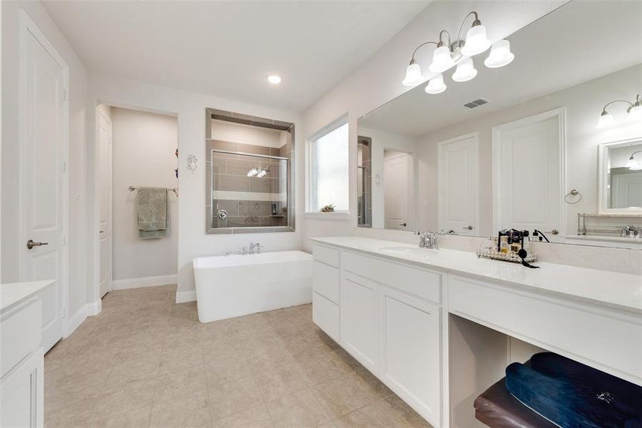 Primary bathroom with dual vanities, freestanding tub & spacious shower