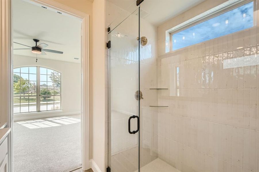 Bathroom with ceiling fan and an enclosed shower