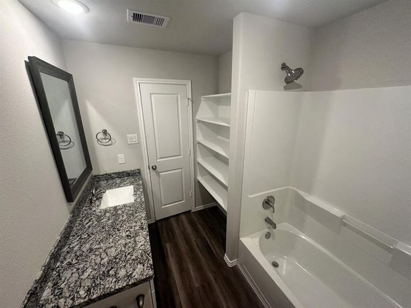 Bath 2 has granite counters & stylish framed mirror too + shelving for storage.