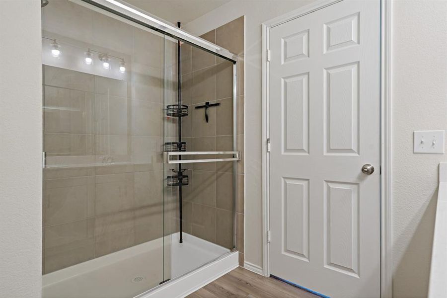 The primary bath features an expansive shower, as well as dual sinks at the vanity.