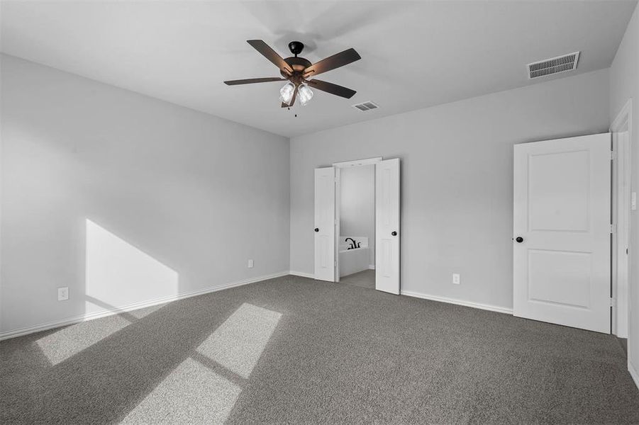 Unfurnished bedroom featuring ceiling fan and carpet floors