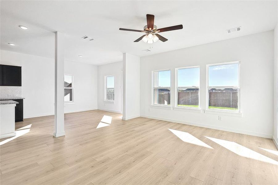 Unfurnished living room with ceiling fan and light hardwood / wood-style flooring