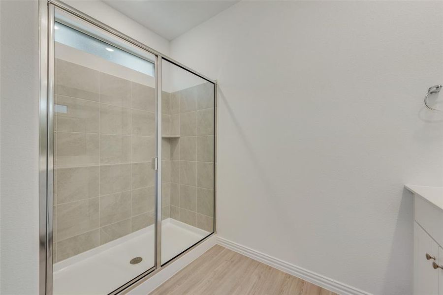 Bathroom featuring vanity, walk in shower, and hardwood / wood-style floors