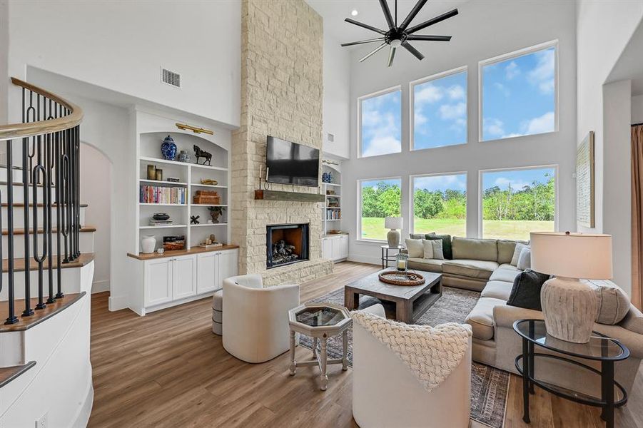 Spacious living area anchored by a stunning fireplace, flanked by elegant custom shelving.