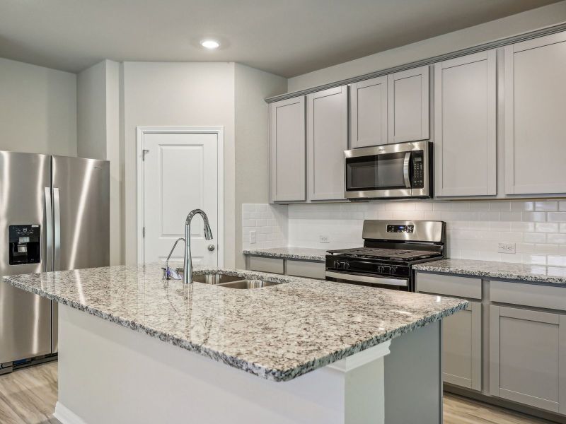 The beautiful kitchen features grey stone-colored cabinets and granite countertops.