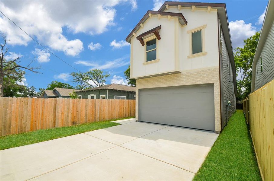 The driveway to two car attached garage has a wrought iron gate that offers ample parking space.