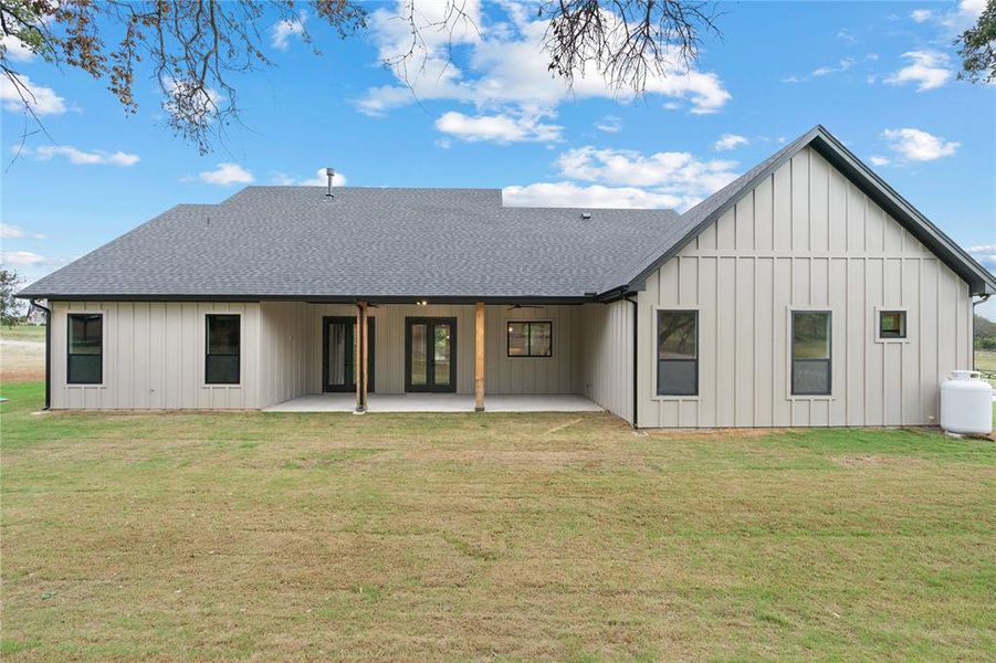 Back of property featuring a patio area and a lawn