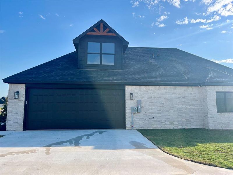 View of front facade featuring a garage and a front yard