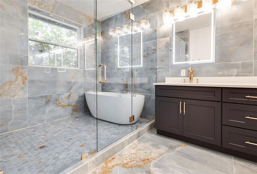 Bathroom with tile walls, tile floors, an enclosed shower, and vanity