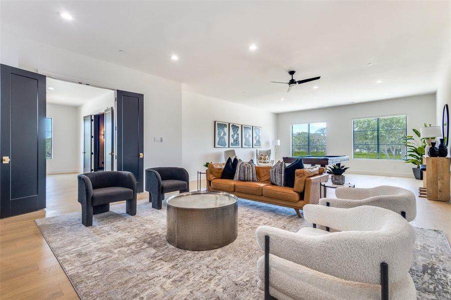 Living room with ceiling fan and light wood-type flooring