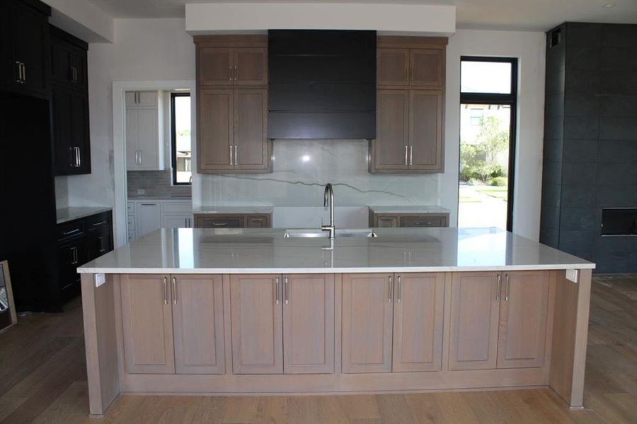 Kitchen featuring a large island, light wood-type flooring, and sink