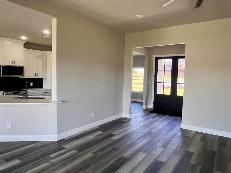 Kitchen featuring dark wood-type flooring, sink, french doors, white cabinets, and appliances with stainless steel finishes