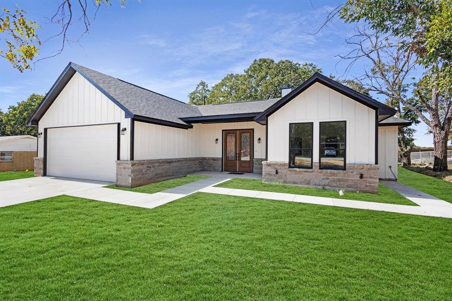 Modern inspired farmhouse with a front yard and a garage