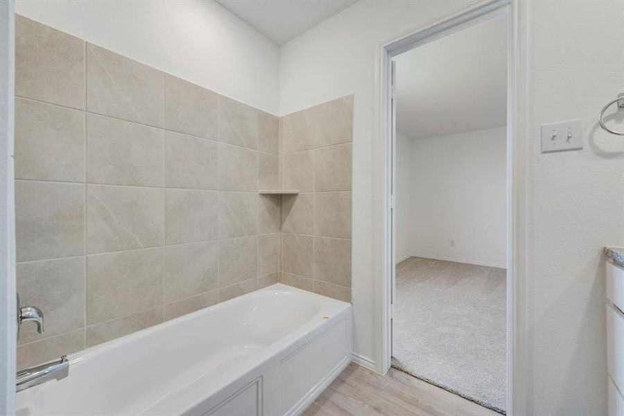 Bathroom featuring hardwood / wood-style flooring and tiled shower / bath combo