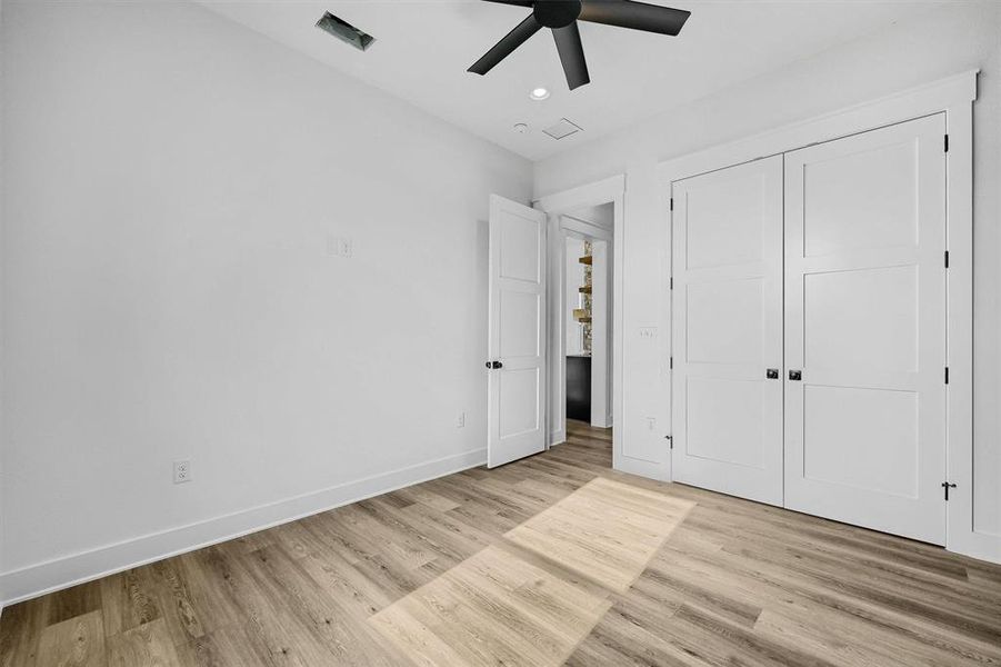 Unfurnished bedroom with light hardwood / wood-style floors, a closet, and ceiling fan