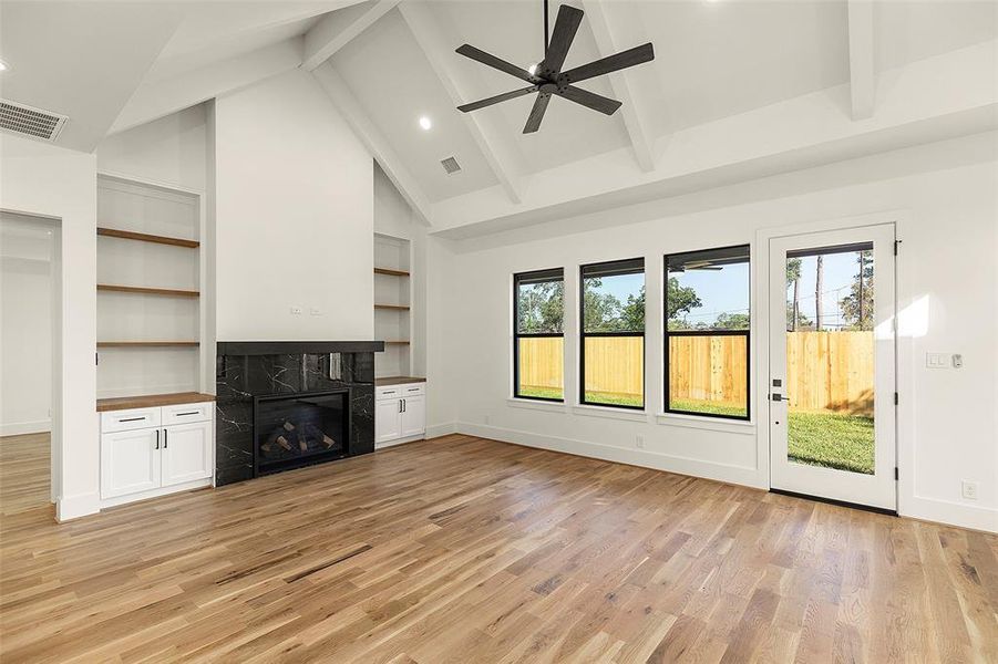 Proceeding further down foyer you enter the wonderful family room with its fireplace, multiple windows looking to the Lanai and backyard, notice the custom wood work on eith side of the fireplace