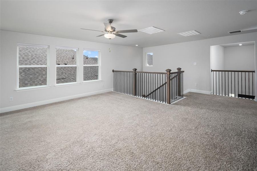 Carpeted spare room with ceiling fan