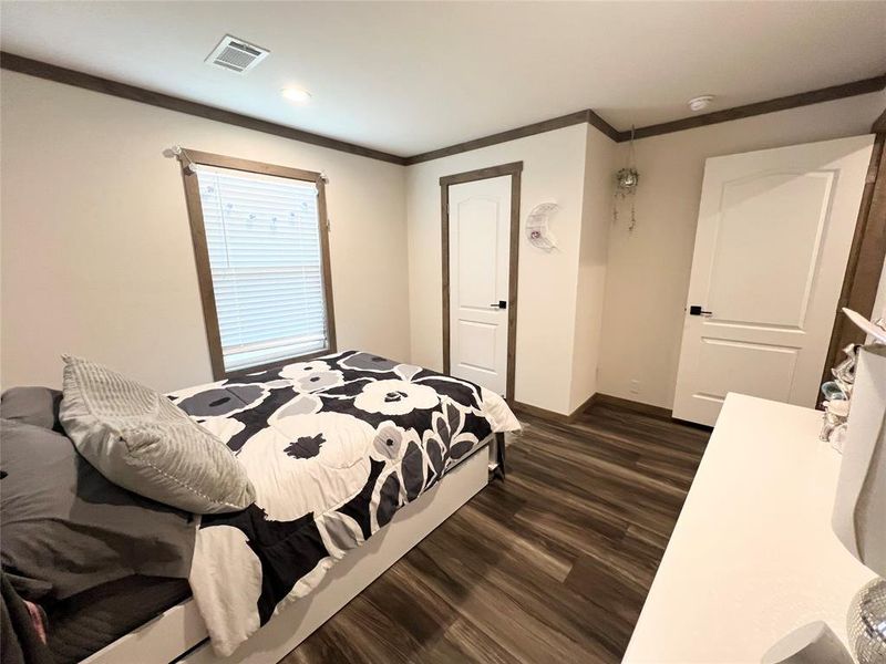 Bedroom featuring crown molding and dark hardwood / wood-style flooring