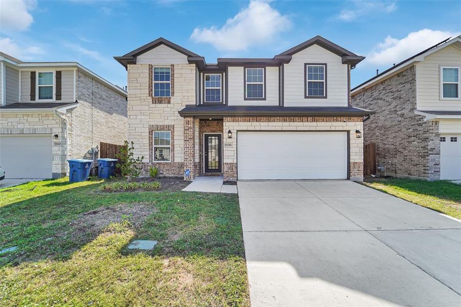 View of property featuring a front yard and a garage