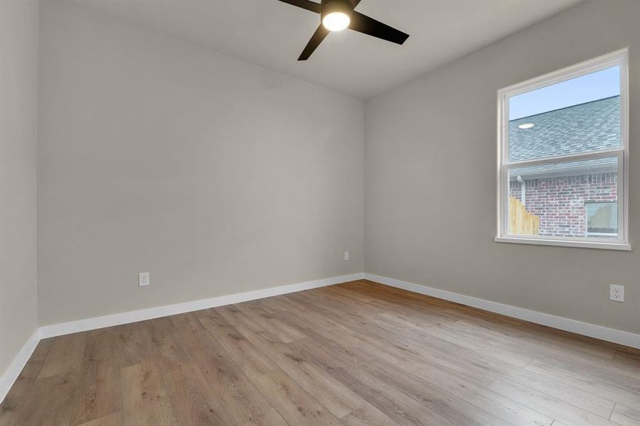 Empty room with light hardwood / wood-style flooring and ceiling fan