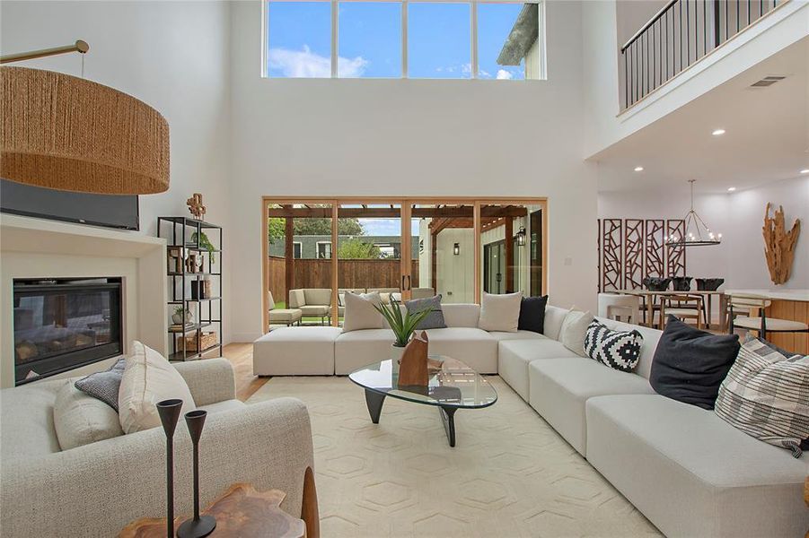 Living room featuring a towering ceiling and a chandelier