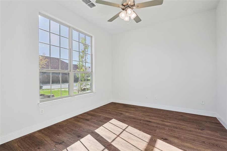 Empty room featuring ceiling fan and hardwood / wood-style flooring