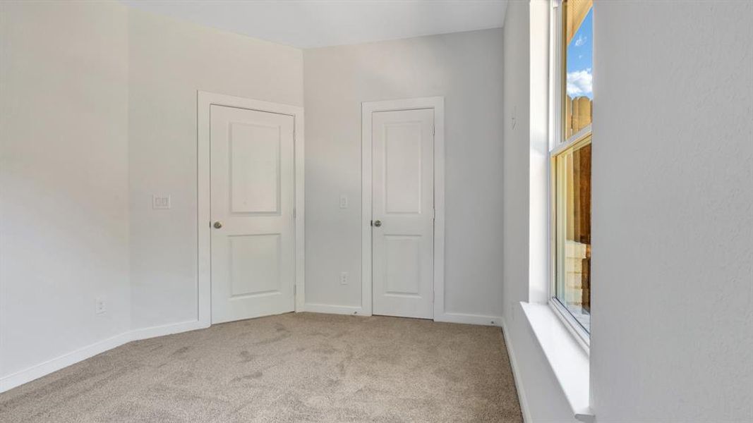 Unfurnished bedroom with light carpet